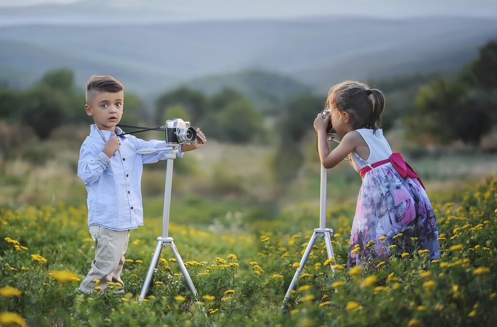  Two children capturing memories with a camera in a vibrant field, surrounded by nature's beauty.